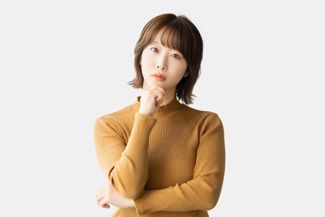 首を傾げて悩んでいる女性