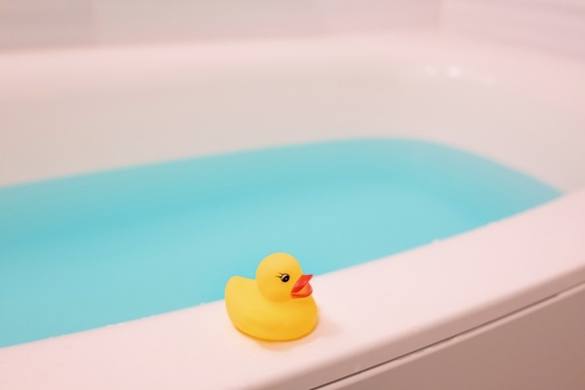 浴槽の縁にアヒルがいる画像